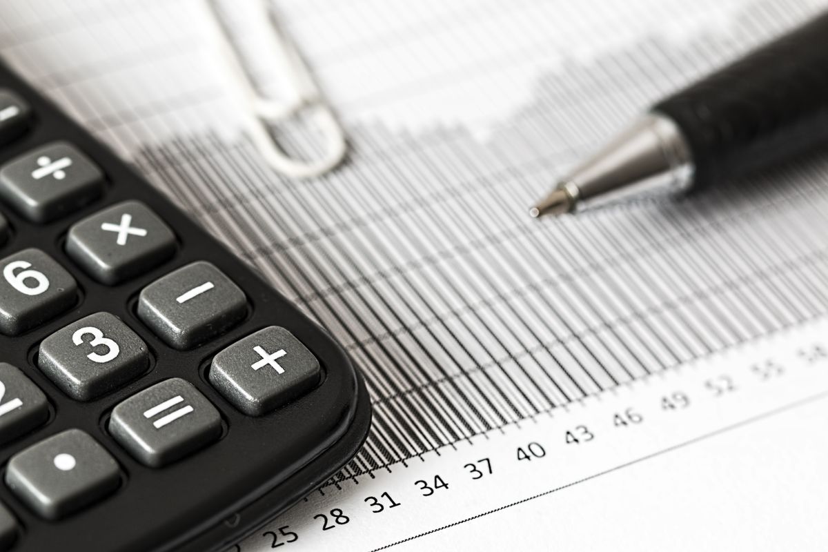 Calculadora e caneta sobre uma planilha financeira impressa