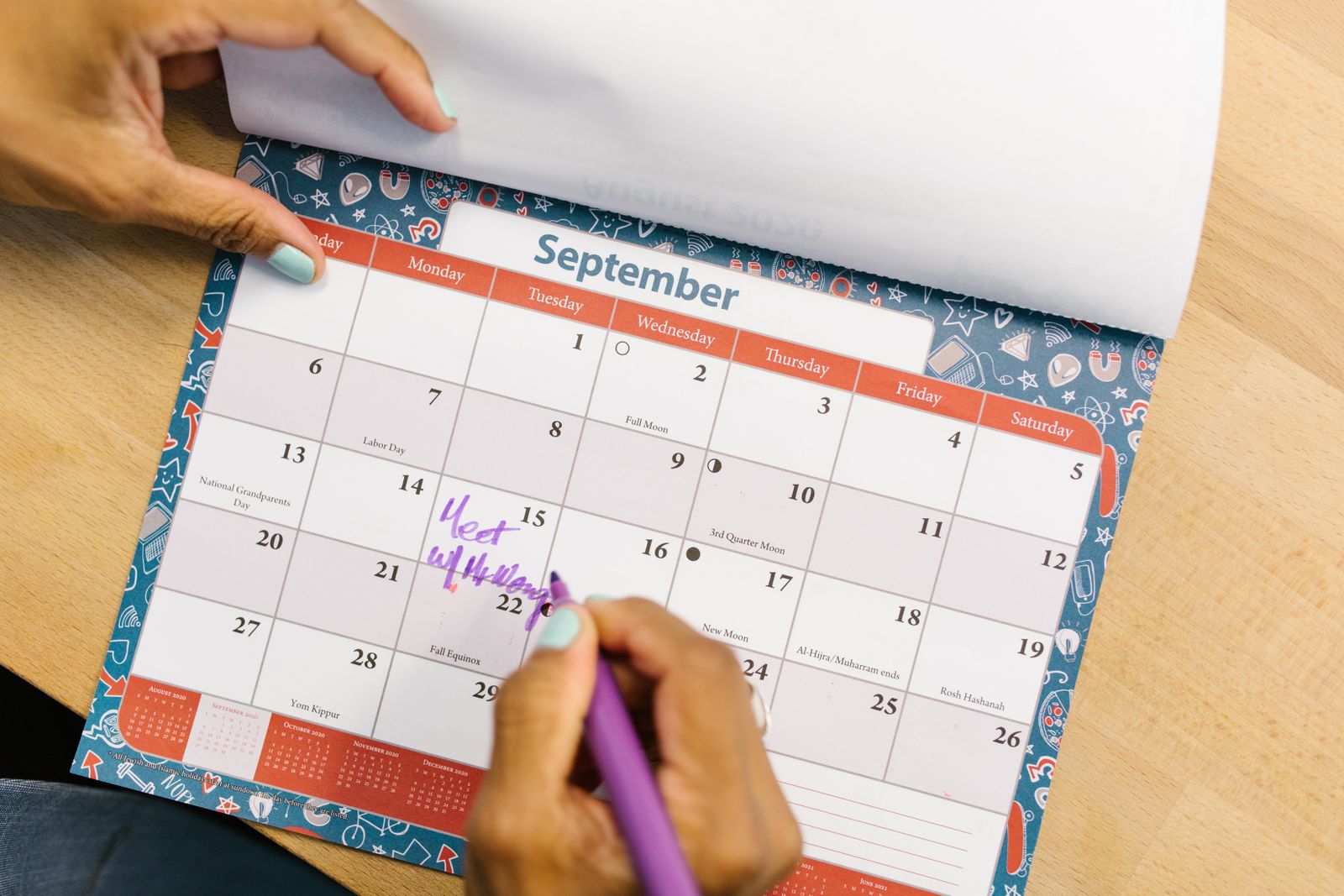 Pessoa marcando uma data no calendário para organizar a agenda de eventos do buffet