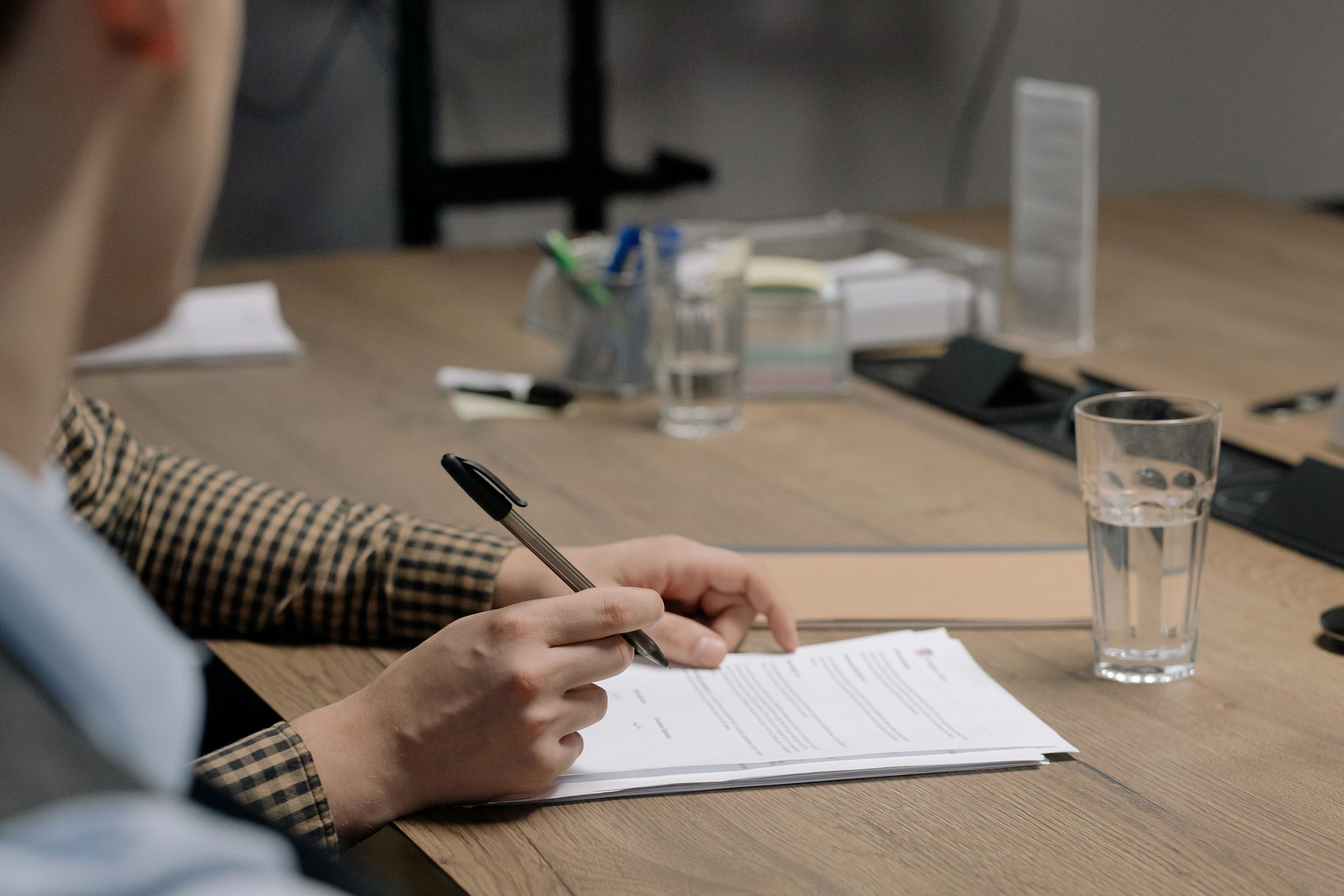 Pessoa assinando contrato de festa em mesa de escritório